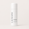 A white cylindrical bottle of LAUMAINE Nourishing Milk essence, featuring black vertical branding text, set against a solid off-white background.